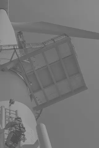 Technician performing maintenance on wind turbine nacelle platform