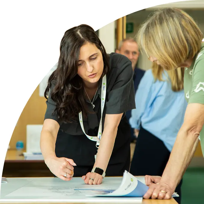 Two women discussing plans over a table with documents